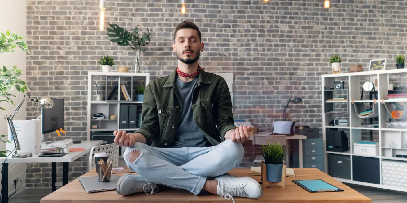 Professionista in ufficio pratica rilassamento per migliorare equilibrio tra lavoro e vita
